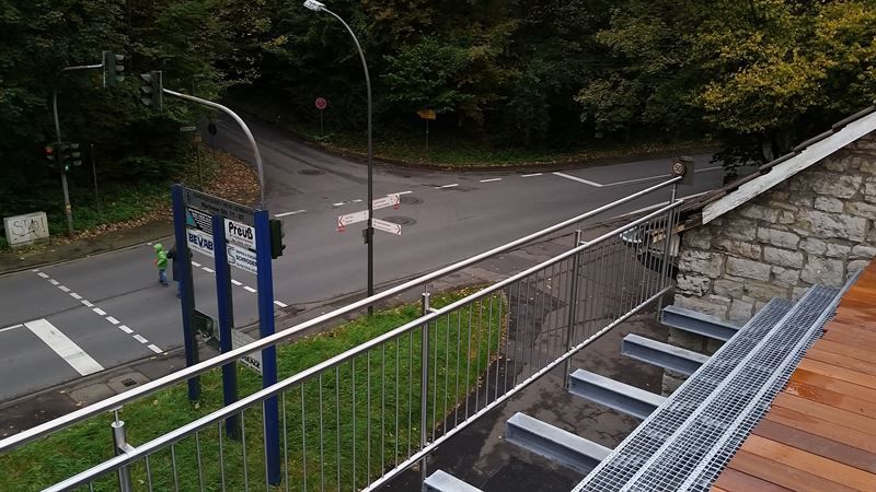 Ein Blick auf eine Straße von einem Balkon mit Blick auf eine Brücke.