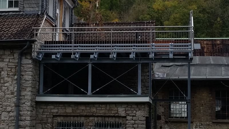 An der Seite eines Gebäudes befindet sich ein Balkon.