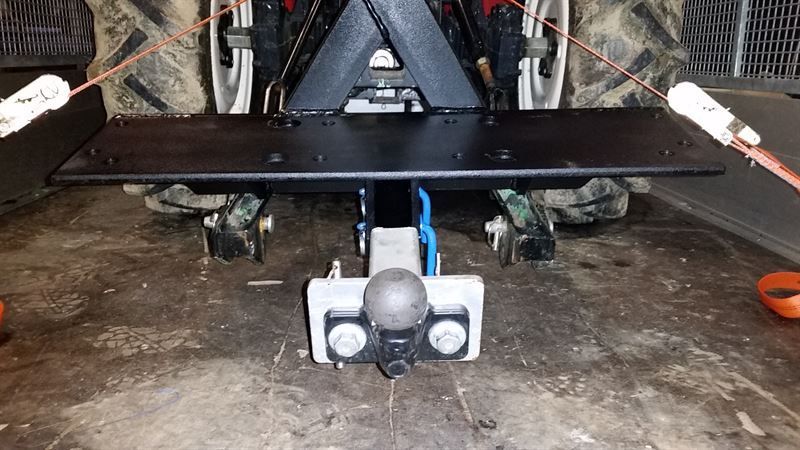 Eine Anhängerkupplung wird an der Rückseite eines Traktors angebracht.