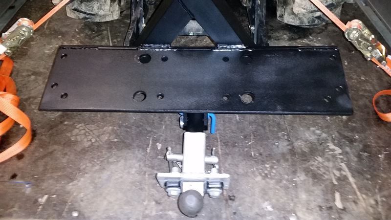 Ein Traktor wird von einem Anhänger mit angeschlossener Anhängerkupplung gezogen.