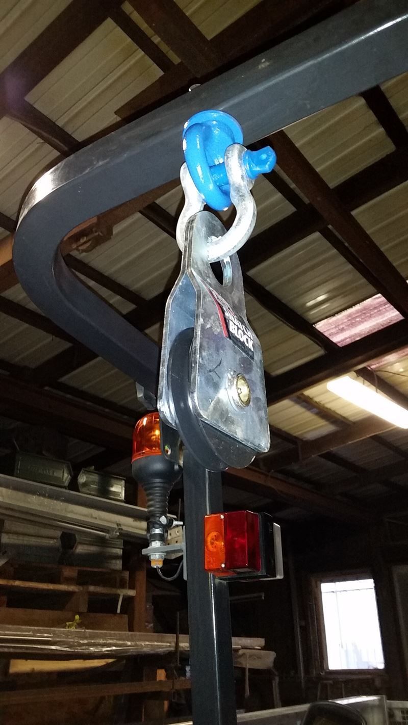 Ein Kranhaken hängt von der Decke eines Gebäudes.