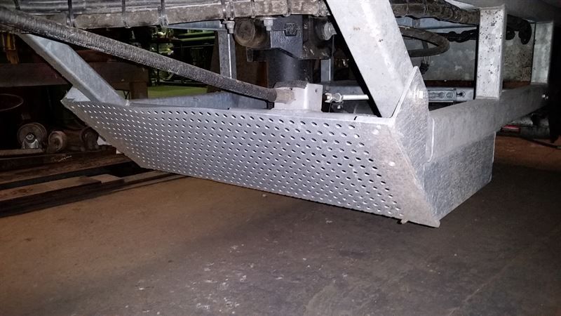 Auf einem Holzboden steht eine Metallkonstruktion.