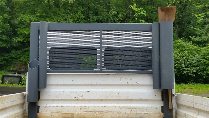 Die Ladefläche eines Muldenkippers mit einem Zaun und einem Schornstein.