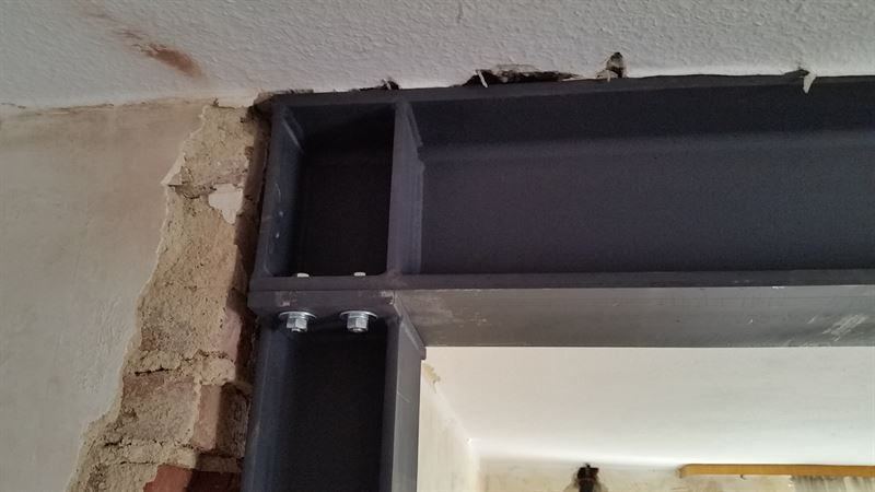 In eine Ziegelwand wird ein Metallträger eingebaut.