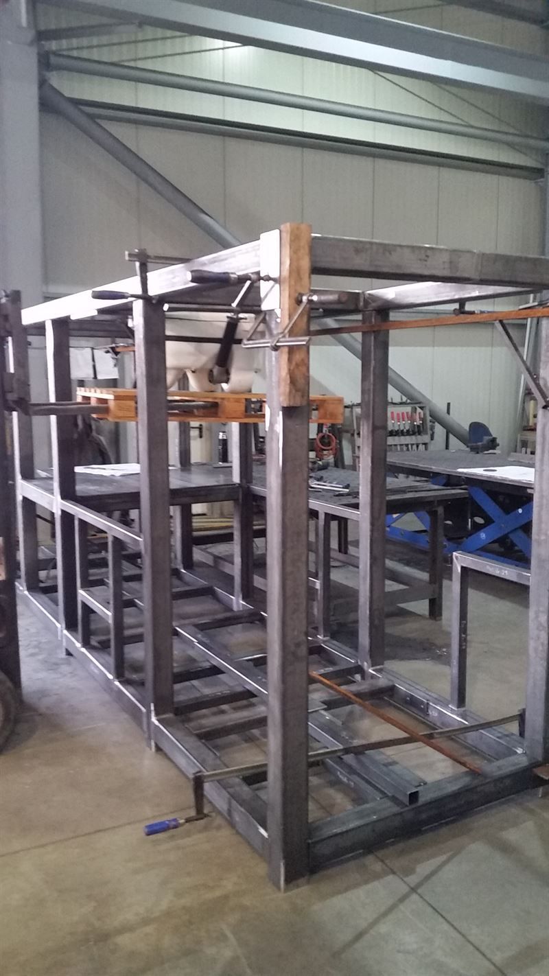 In einer Fabrik wird eine große Metallkonstruktion errichtet.