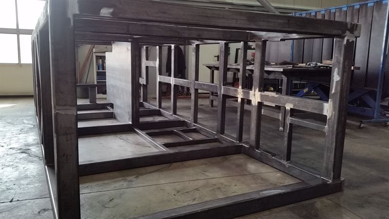 In einem Raum steht ein Metallrahmen auf dem Boden.