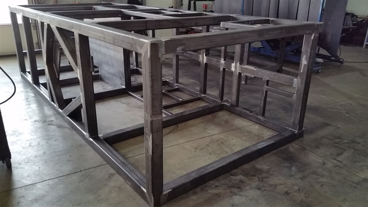 In einem Raum steht ein Metallrahmen auf einem Betonboden.