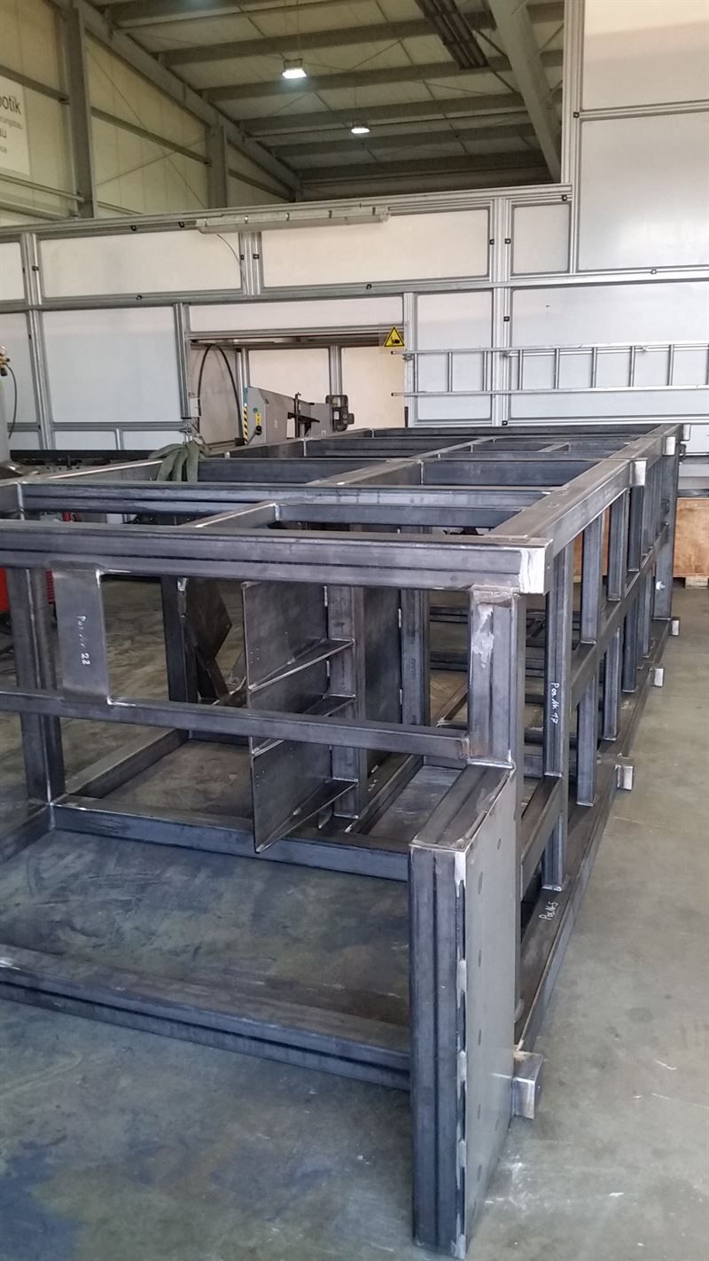 In einer Fabrik wird eine große Metallkonstruktion errichtet.