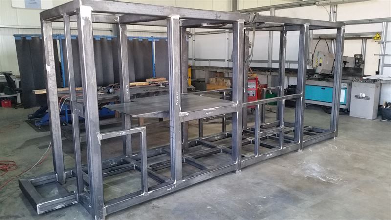 In einer Fabrik wird eine große Metallkonstruktion errichtet.