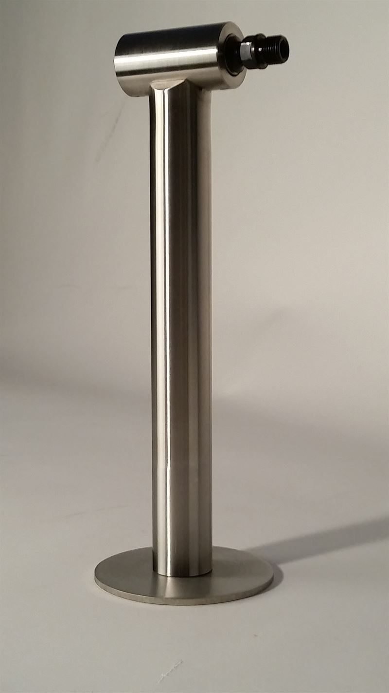 Auf einer weißen Fläche steht ein Flaschenhalter aus Edelstahl.