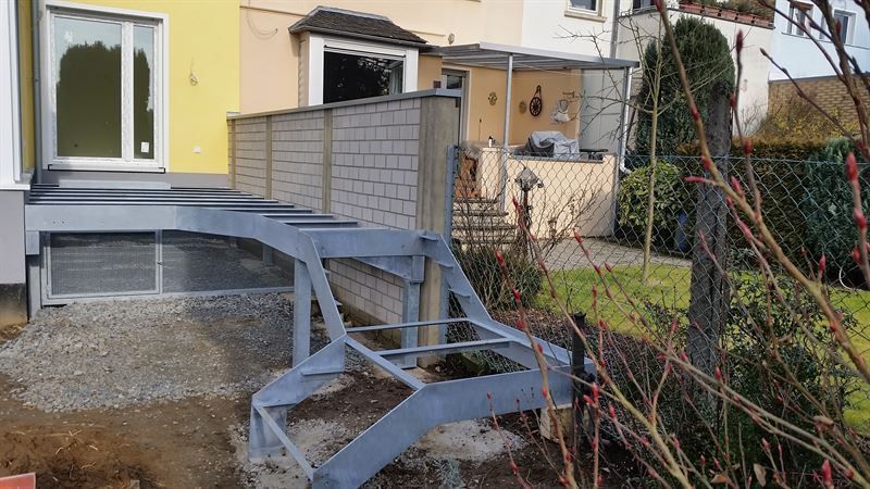Vor einem Haus wird eine Metalltreppe gebaut.