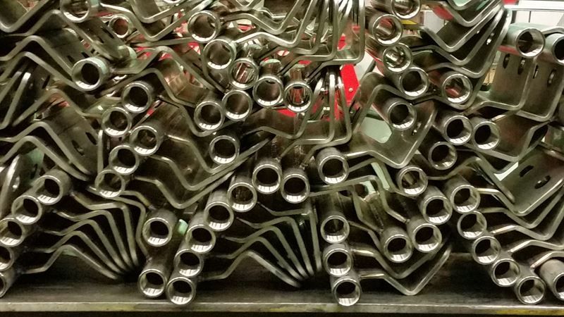 Auf einem Regal sind mehrere Metallteile übereinander gestapelt.