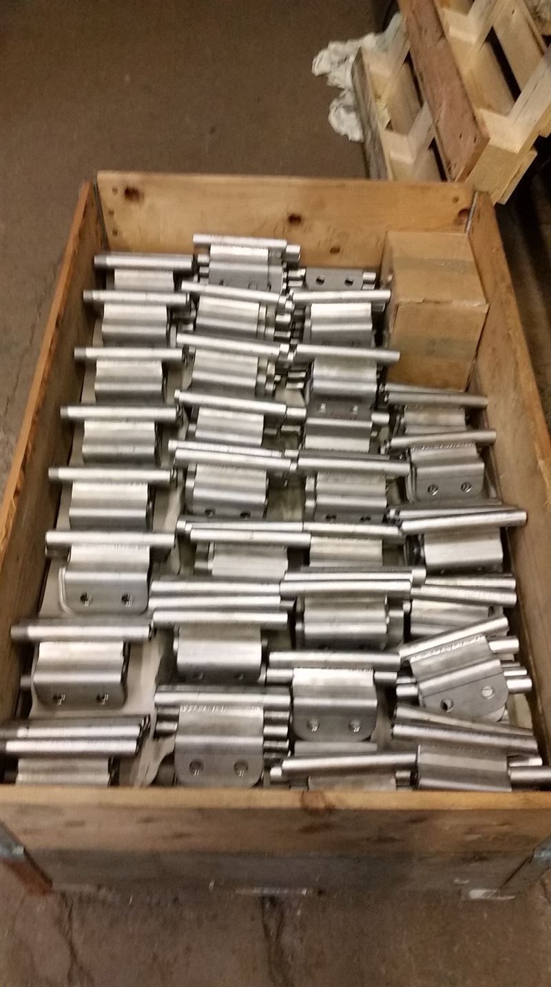 Eine Holzkiste gefüllt mit vielen Metallteilen.