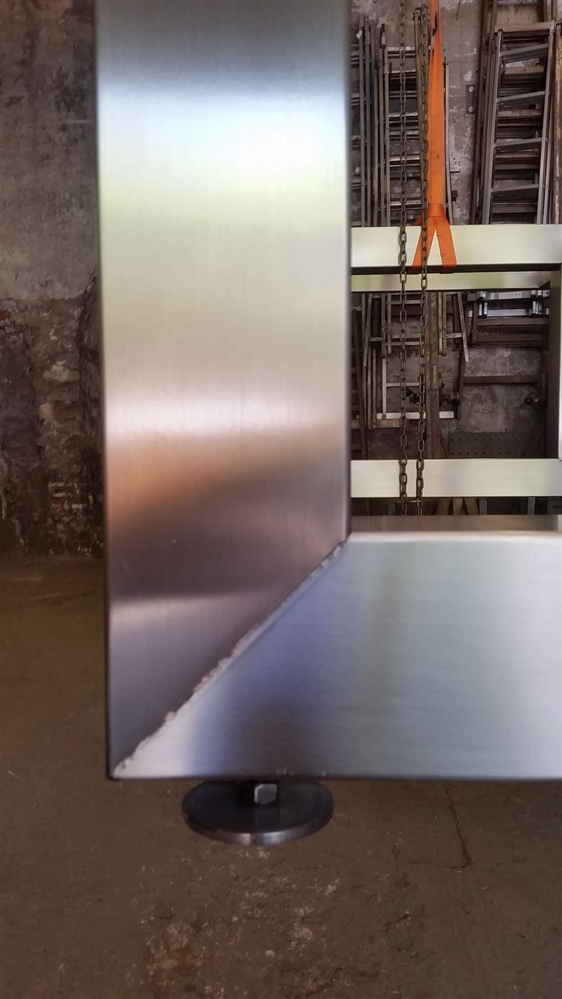 In einem Raum steht eine Edelstahlwand auf dem Boden.