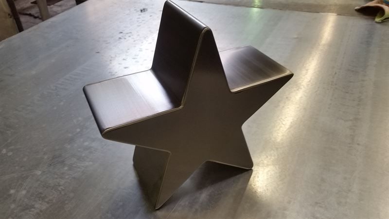 Ein Metallstern sitzt auf einer Metalloberfläche.