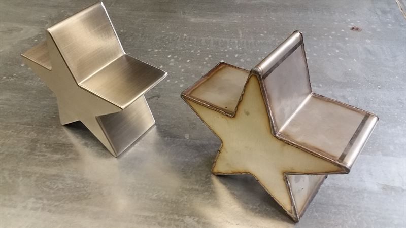 Zwei Metallsterne sitzen auf einer Metalloberfläche.