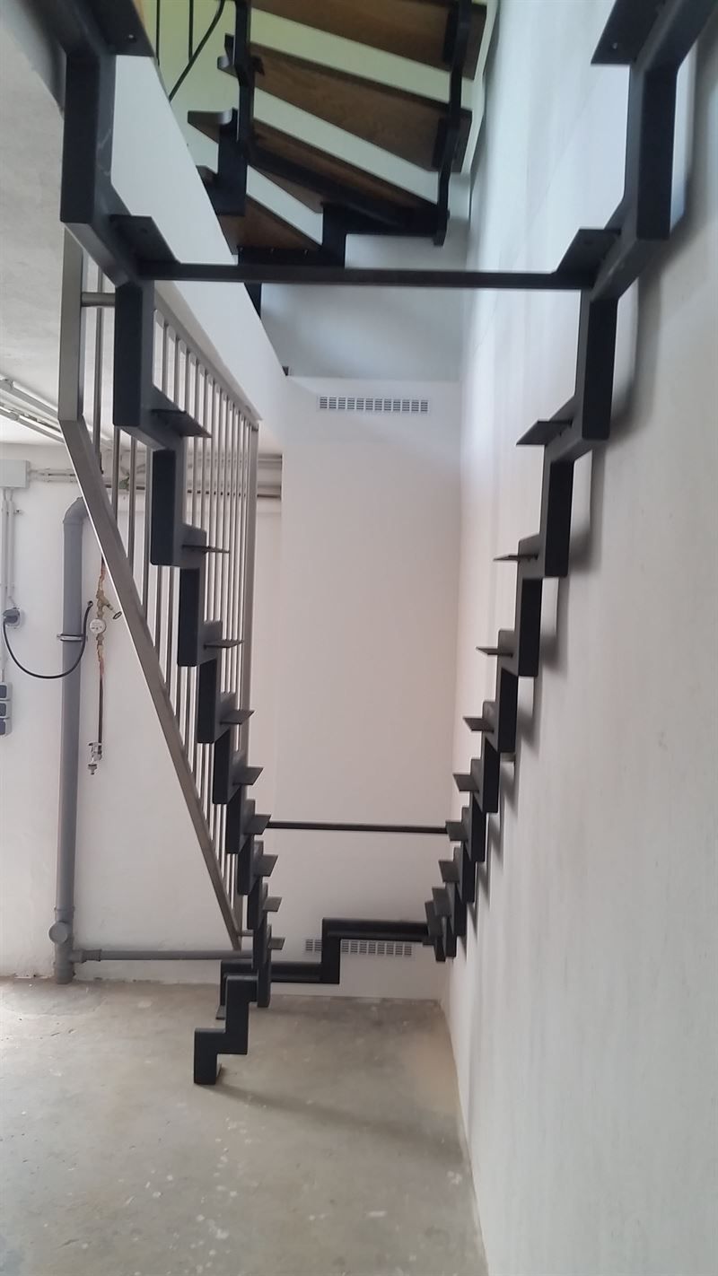 In einem Gebäude führt eine Treppe eine Wand hinauf.