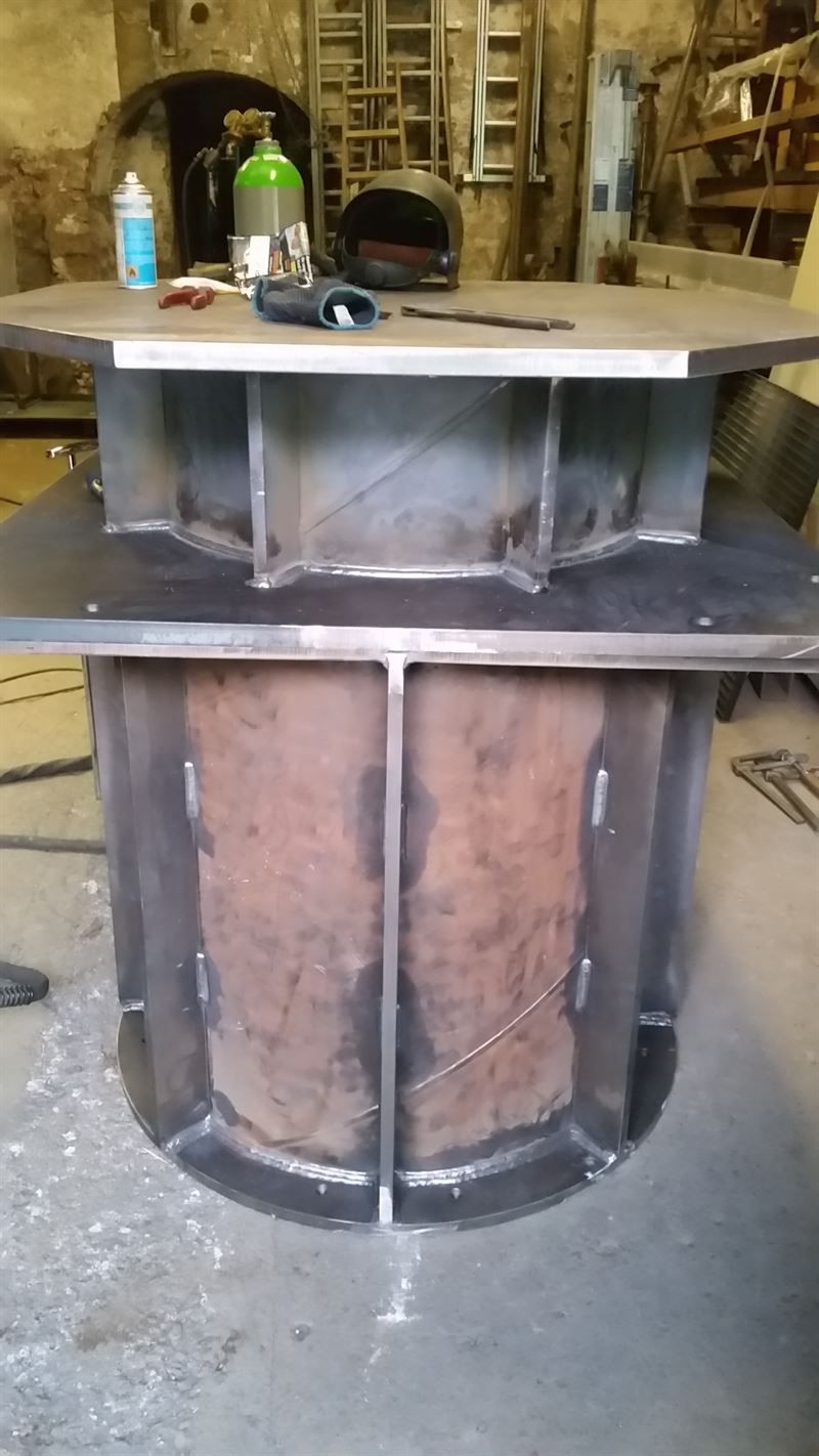 Ein großer Metallzylinder steht auf einem Tisch in einer Fabrik.