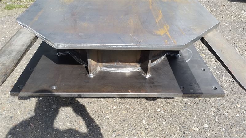 Ein Metallgegenstand liegt auf einer Betonoberfläche.