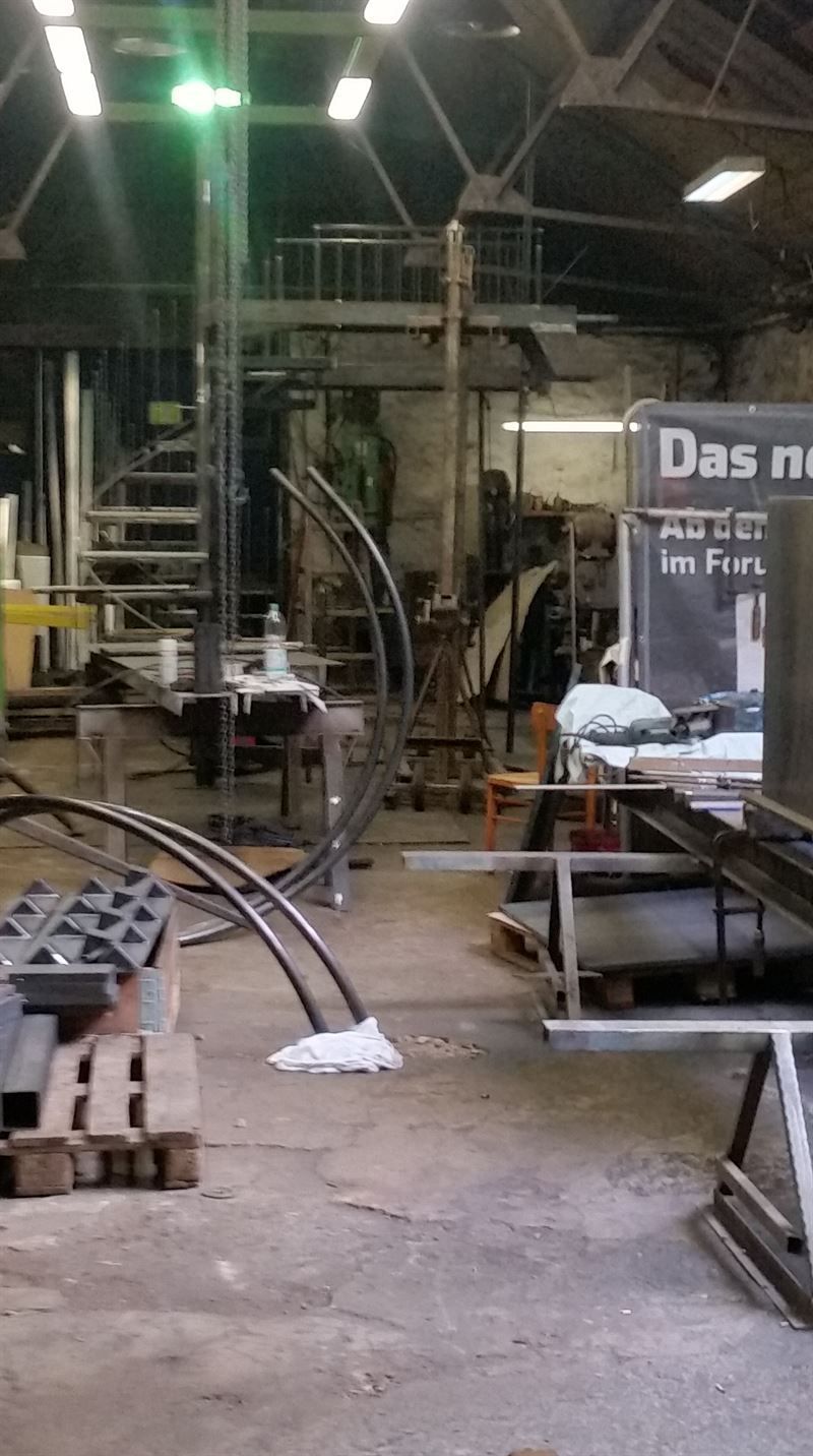 In der mitte des raumes hängt ein schild mit der aufschrift „das neu“.