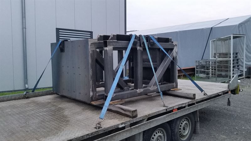 Auf einem Anhänger liegt ein großes Stück Metall.