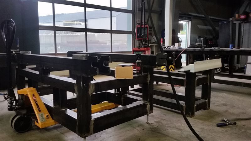 Ein gelber Hubwagen steht auf einer Metallkonstruktion in einer Fabrik.