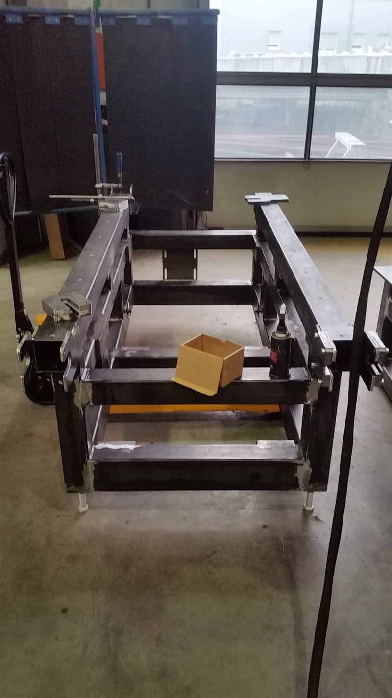 In einem Raum steht ein Karton auf einer Metallkonstruktion.