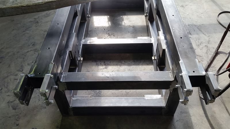 Auf einem Betonboden befindet sich eine Metalltreppe.