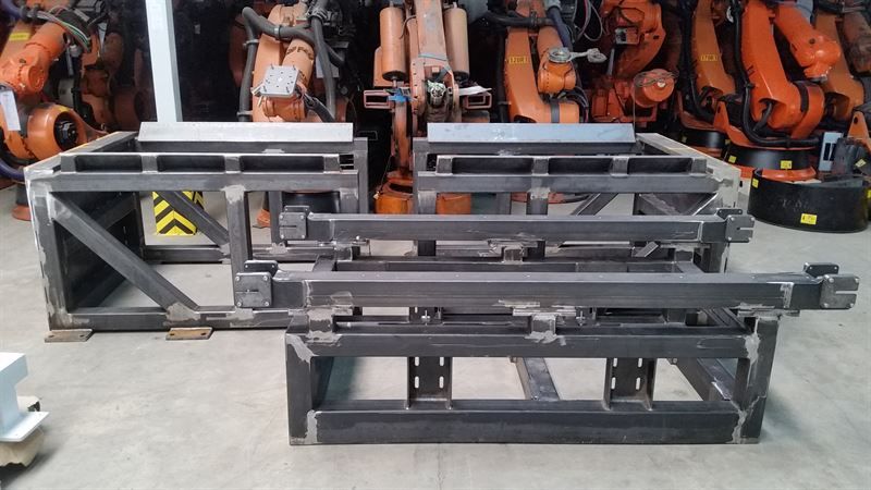 In einem Lagerhaus sind mehrere Metallrahmen übereinander gestapelt.