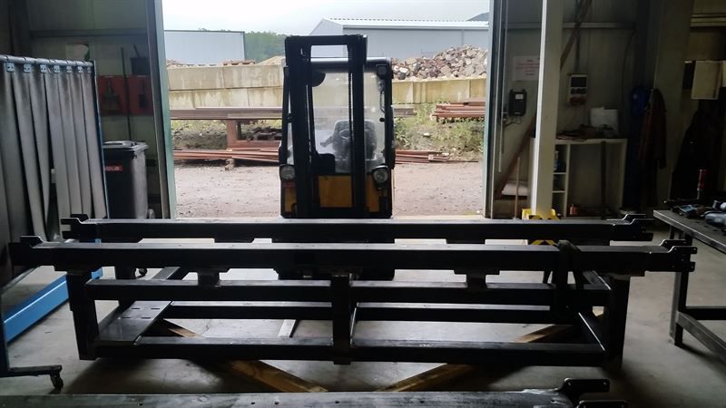 Ein Gabelstapler steht auf einer Metallkonstruktion in einer Garage.