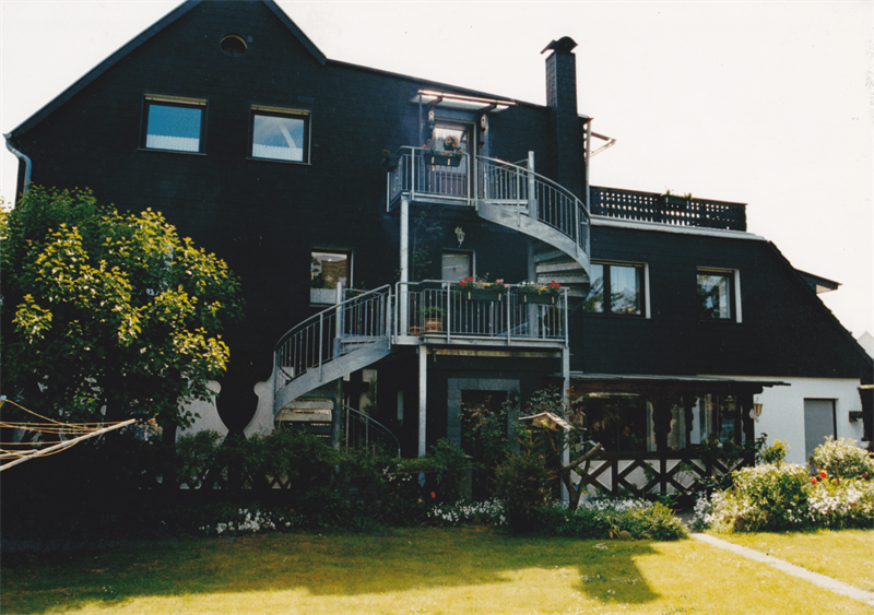 Ein schwarzes Haus mit einer Wendeltreppe an der Seite