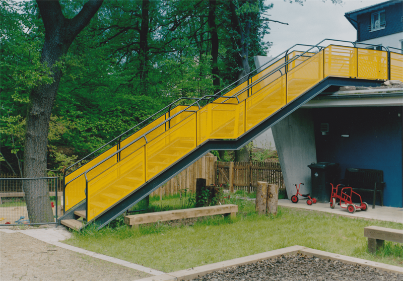 Eine gelbe Treppe, die zu einem blauen Gebäude führt