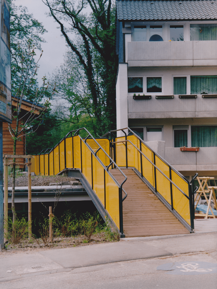 Eine gelbe Treppe führt hinauf zu einem Gebäude