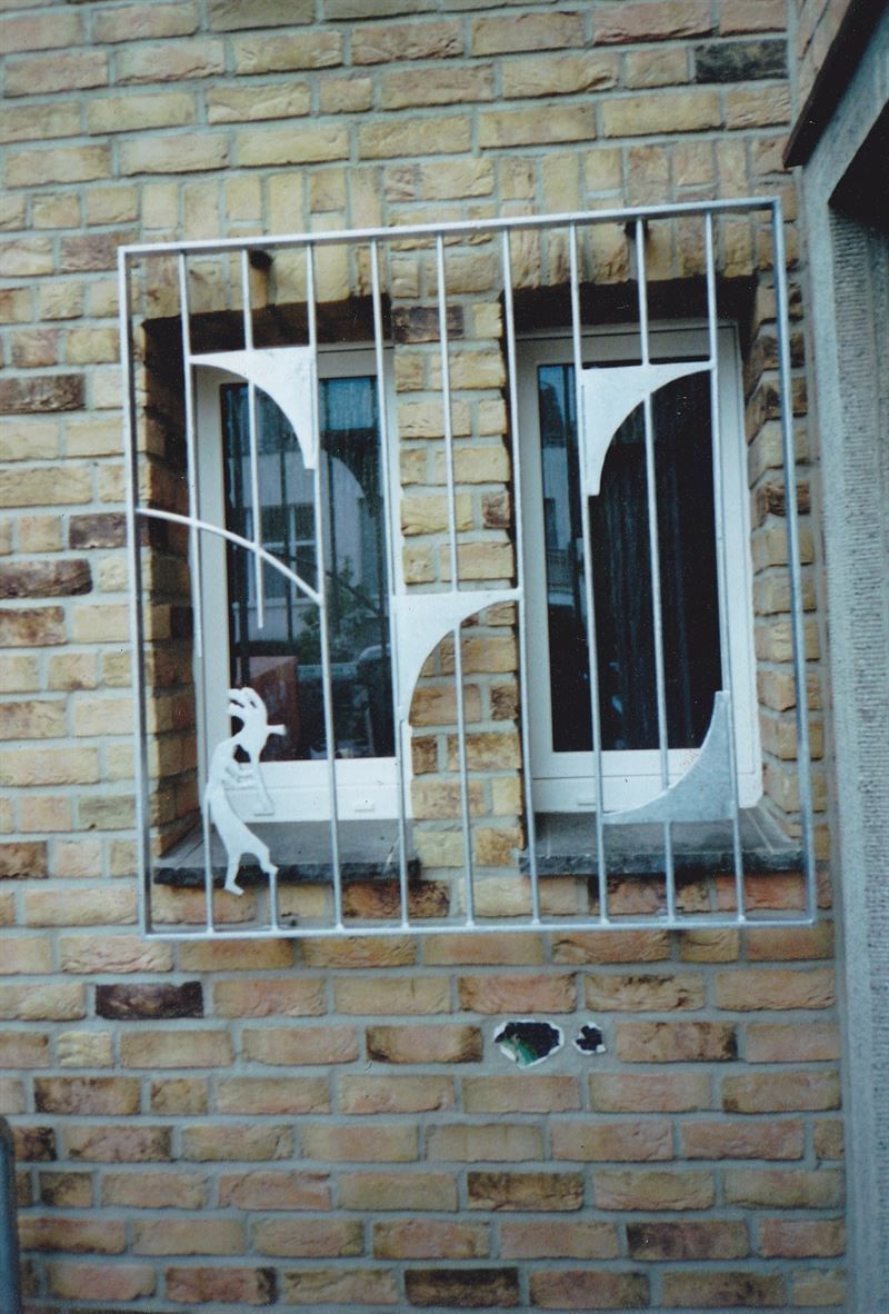 Eine Backsteinmauer mit einem Fenster und einem Zaun darum