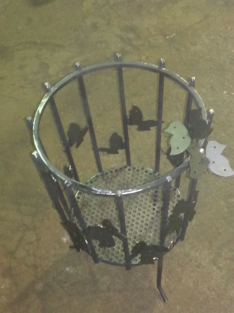 Ein Metallkorb mit Vögeln und Blättern darauf