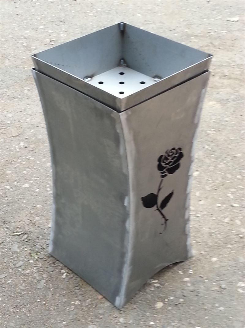 Auf dem Boden steht eine Edelstahlvase mit einer Rose darauf.