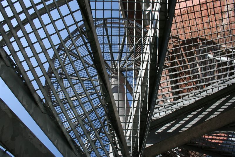 Blick nach oben auf eine Wendeltreppe mit blauem Himmel im Hintergrund