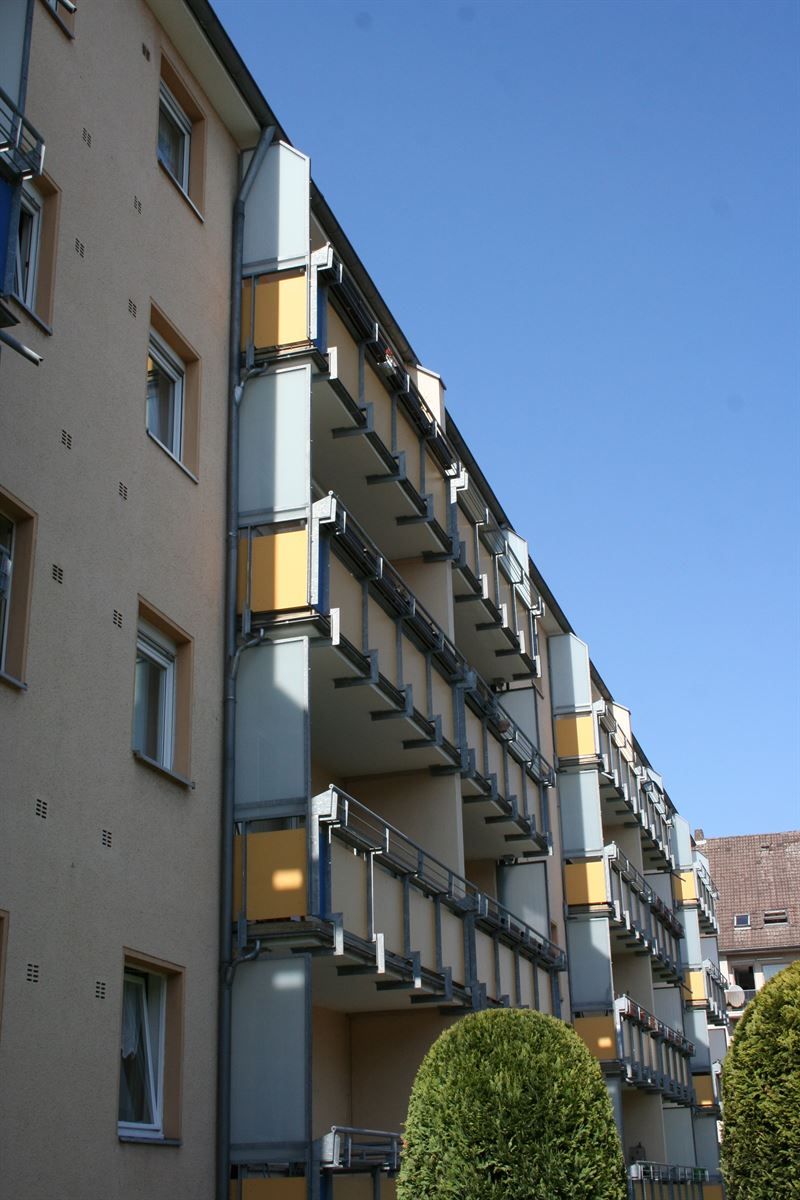 Ein großes Mehrfamilienhaus mit vielen Balkonen