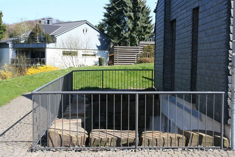 Ein Zaun umgibt eine Treppe, die zu einem Haus hinaufführt