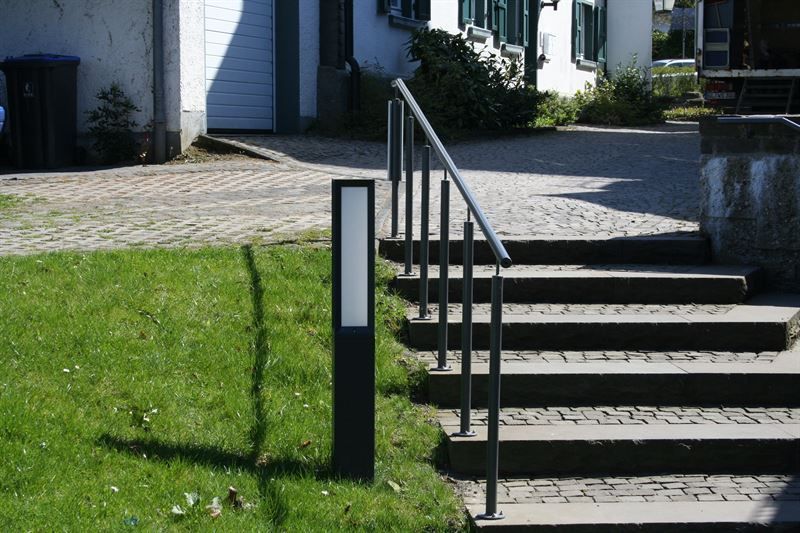 Eine Treppe, die zu einem Haus mit Geländer führt