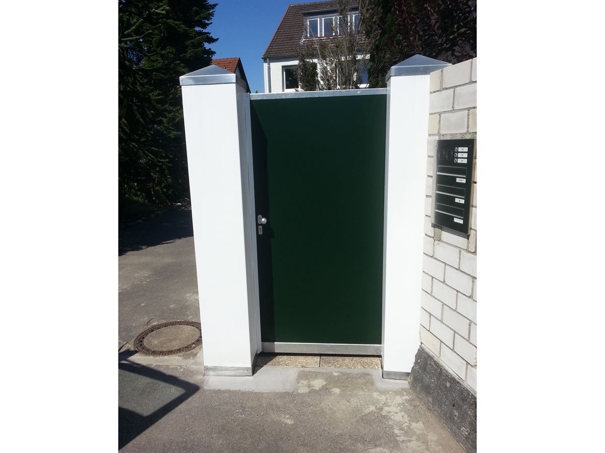 Ein grünes Tor befindet sich zwischen zwei weißen Säulen