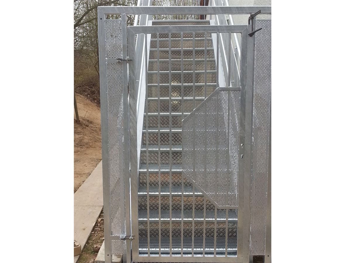 Ein Metalltor, das zu einer Treppe führt.