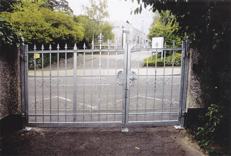 Ein Metalltor ist zu einem Parkplatz geöffnet