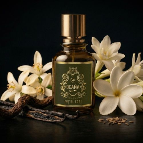 Frasco de perfume de cristal ámbar con tapón dorado y etiqueta verde oliva.