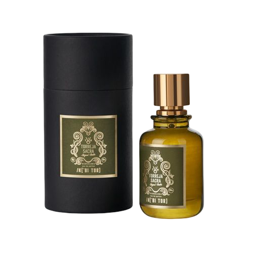 Frasco de perfume y caja cilÃndrica a juego, ambos con etiquetas verdes sobre fondo negro. Detalles dorados.