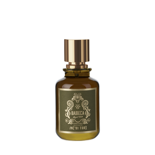 Frasco de perfume de color ámbar con tapón y etiqueta dorados.