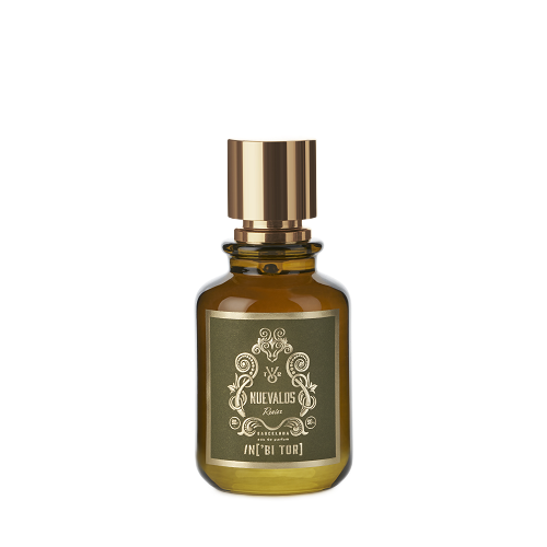 Frasco de perfume de color ámbar con tapón dorado y etiqueta verde sobre fondo blanco.