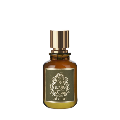Frasco de perfume de cristal ámbar con tapón dorado y etiqueta verde oliva.