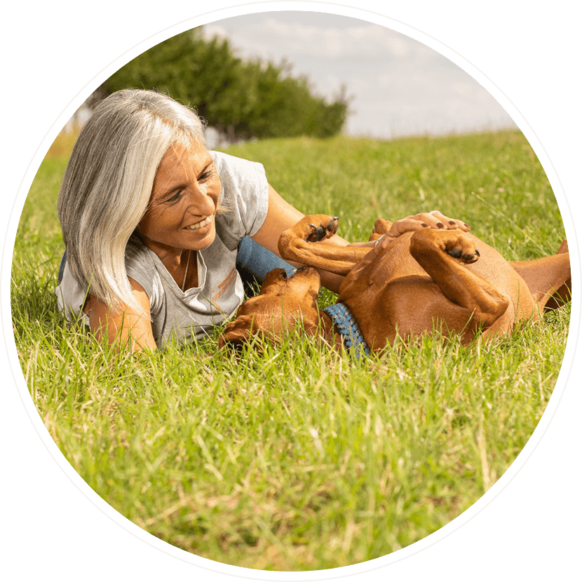 Sportliche Frau mit Hund auf einer Mauer