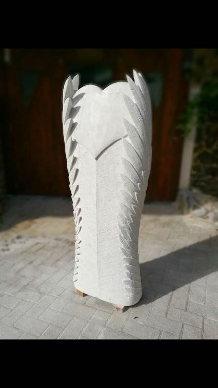 hohe Steinskulptur mit Herz und Federmotiv an den Seiten